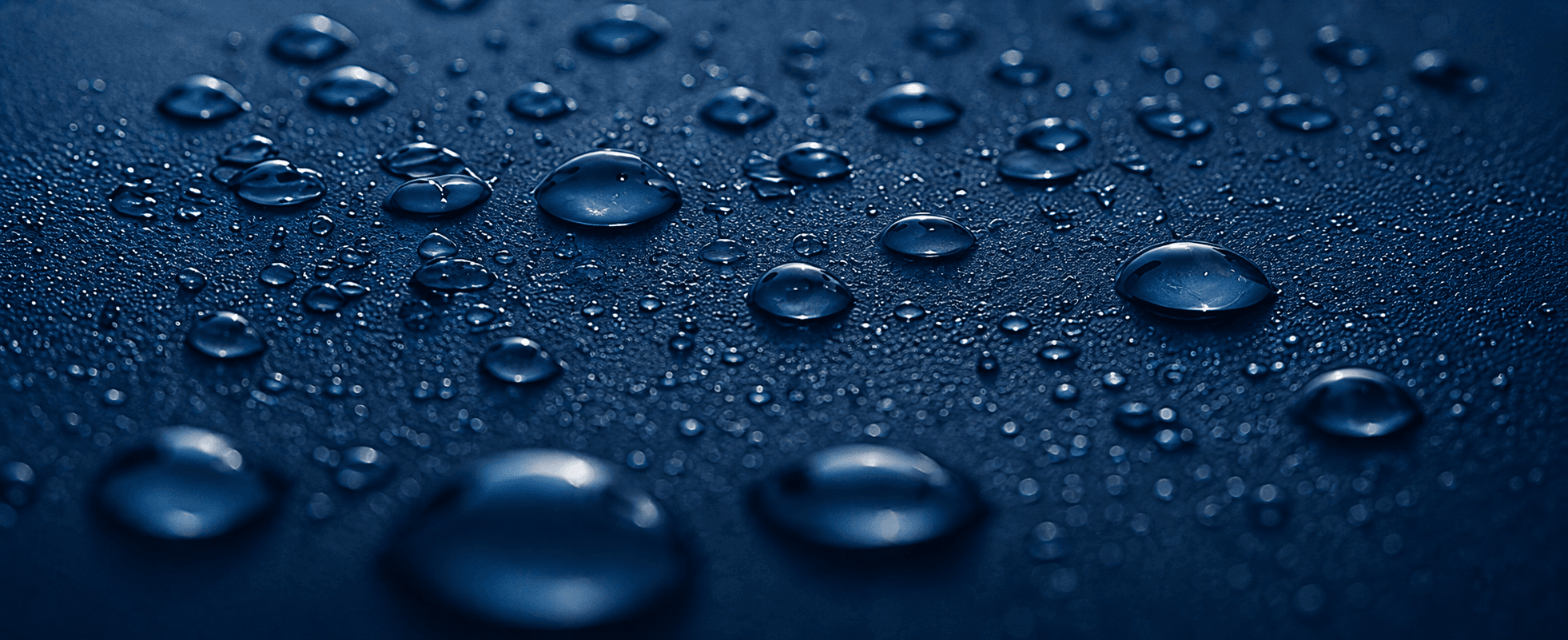 Drops of pure water on a dark blue surface